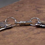 Chrome-plated zinc, premium quick-release key holder Detaches separates into two sets of keys Nickel-plated tempered steel 1" split-rings Cylindrical shape